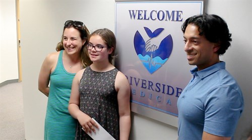 Dr Veronique Ram (l) and Dr. Rithesh Ram (r) pose for a picture with Keira Treller, who designed the Riverside Medical logo.