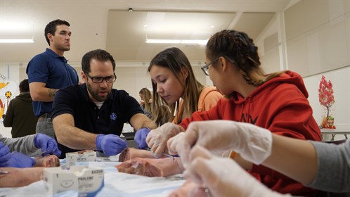 Advanced care paramedic Vincent Dazé teaches students suturing at the skills day event.