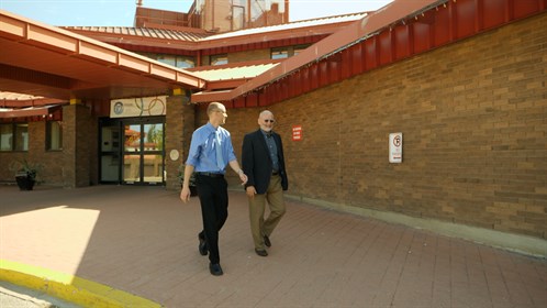RhPAP Executive Director, Bernard Anderson walks with Dr. Hendrik van der Watt outside the Bonnyville Healthcare Centre