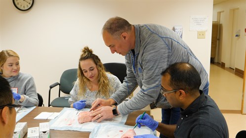 Mark Simons, a physician assistant at the Milk River Health Centre shows students the proper technique for suturing.