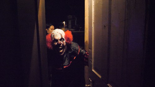 A scary clown greets post secondary students from Calgary at Creepy Hollow, north or Warner, AB, just before Halloween.