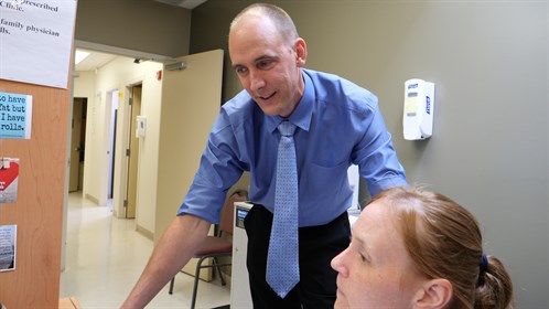 Dr. Hendrik van der Watt meets with a medical office assistant at his clinic in Bonnyville.