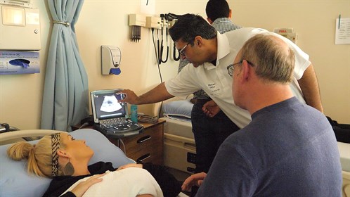 Dr. Doewe Kits, (R) an emergency room physician in Brooks receives direction from Dr. Bilal Mir.